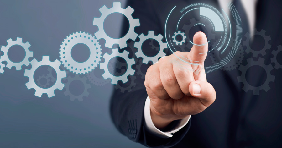 A business person touching a digital illustration of gears turning