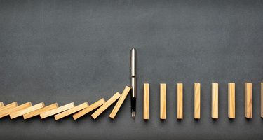 A line of wooden dominos falling down